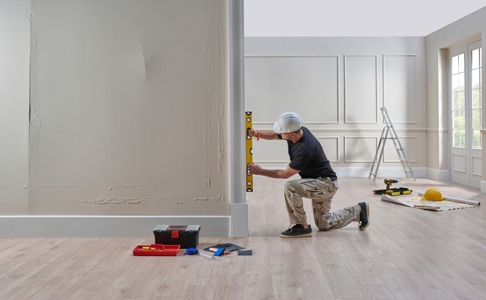 Renovatieschilder werkt aan woning in moderne interieurstijl onder begeleiding van interieurarchitect